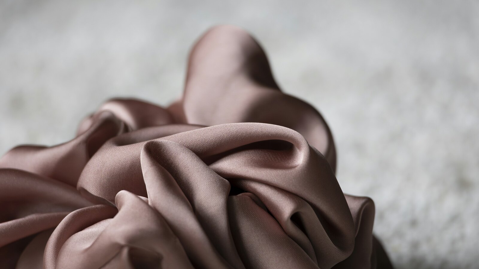 Folded blush pink silk on a soft neutral surface