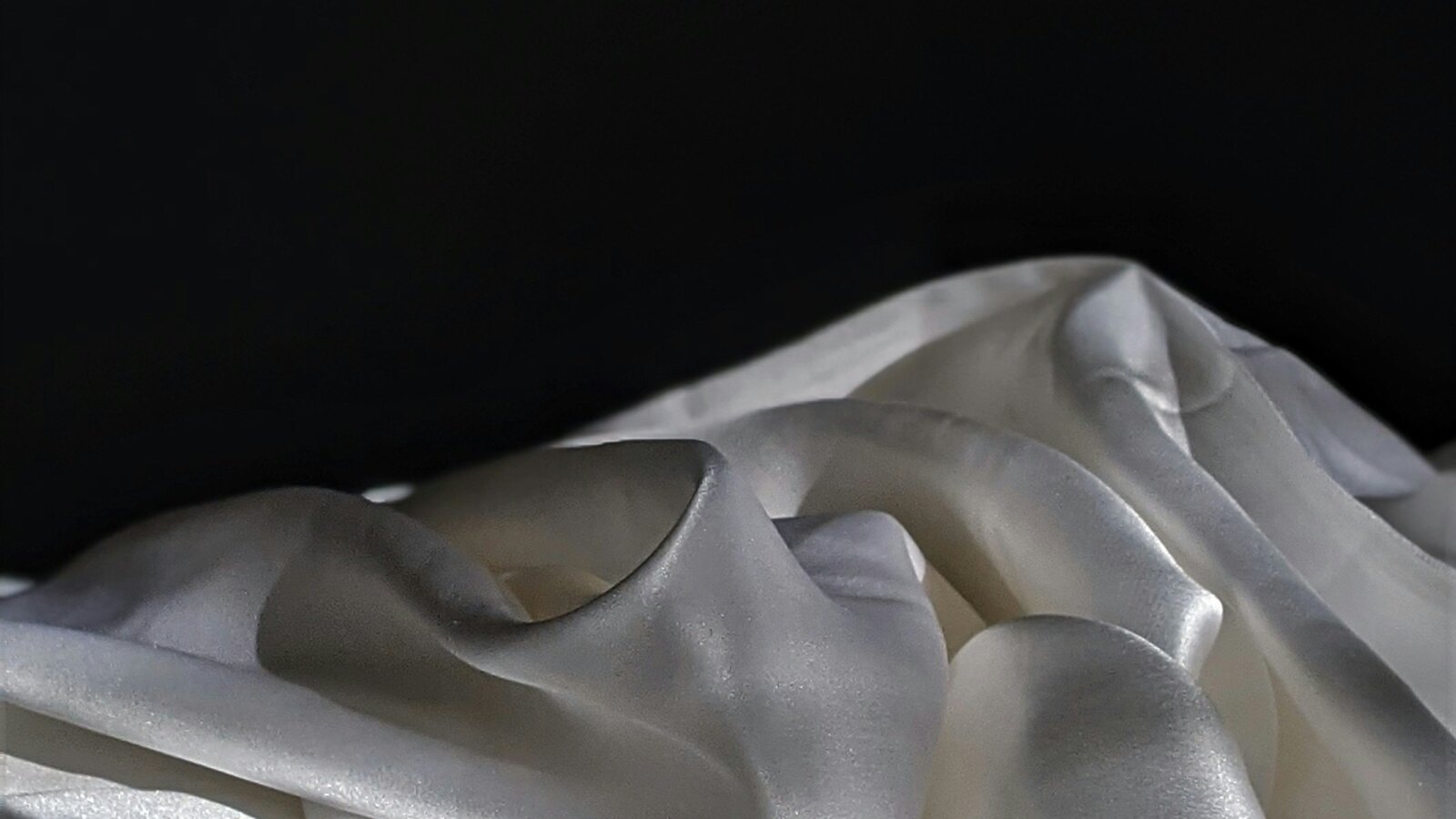 Soft draped ivory silk on a neutral surface